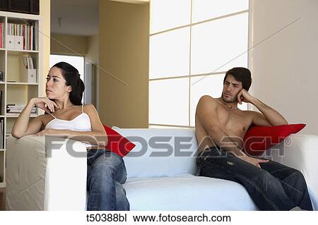 Couple in disagreement sitting on sofa View Large Photo Image Stock Image - Couple in disagreement sitting on sofa. Fotosearch