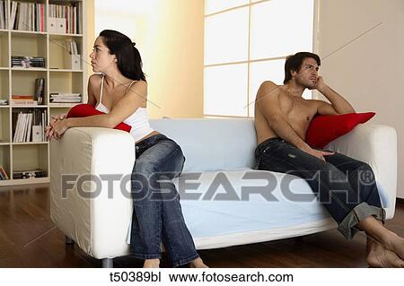 Couple in disagreement sitting on sofa View Large Photo Image Stock Image - Couple in disagreement sitting on sofa. Fotosearch