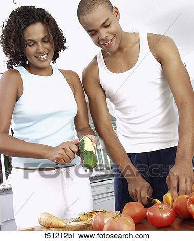 Couple in the kitchen preparing food View Large Photo Image Stock Image - Couple in the kitchen preparing food. Fotosearch