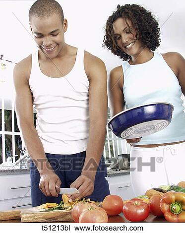 Couple in the kitchen preparing food View Large Photo Image Stock Image - Couple in the kitchen preparing food. Fotosearch