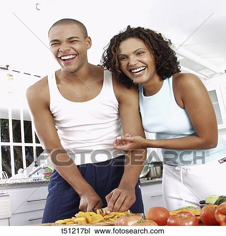 Couple in the kitchen preparing food View Large Photo Image Stock Image - Couple in the kitchen preparing food. Fotosearch