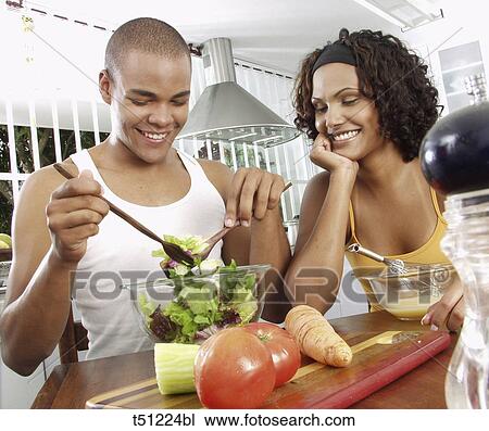 Couple in the kitchen preparing food View Large Photo Image Stock Image - Couple in the kitchen preparing food. Fotosearch