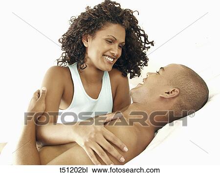 Couple lying on bed View Large Photo Image Stock Image - Couple lying on bed. Fotosearch