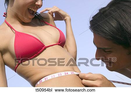 Couple, man measuring women's waist View Large Photo Image Stock Image - Couple, man measuring women's waist. Fotosearch