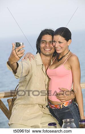 Couple taking an outdoor self-portrait View Large Photo Image Stock Image - Couple taking an outdoor self-portrait. Fotosearch