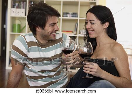 Stock Image - Couple toasting with red wine. Fotosearch