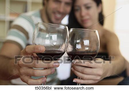 Stock Image - Couple toasting with red wine. Fotosearch