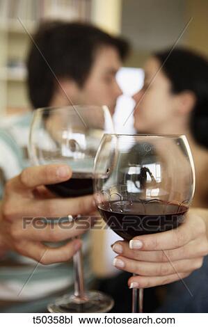 Stock Image - Couple toasting with red wine. Fotosearch