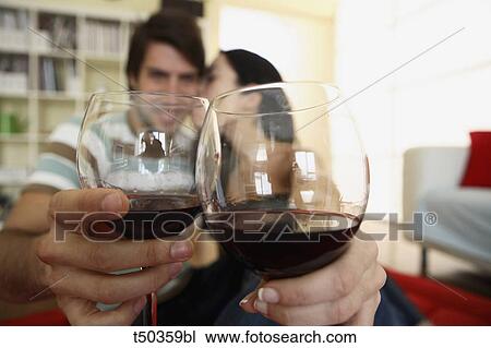 Stock Image - Couple toasting with red wine. Fotosearch