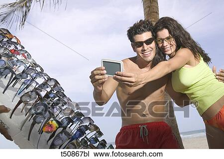 Couple trying on sunglasses View Large Photo Image Stock Image - Couple trying on sunglasses. Fotosearch