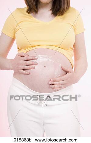 detail of pregnant young woman applying lotion on her belly to avoid stretch marks View Large Photo Image Stock Image - detail of pregnant young woman applying lotion on her belly to avoid stretch marks. Fotosearch