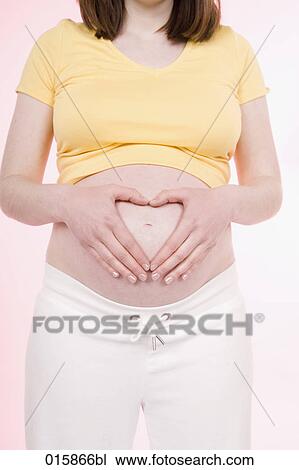 detail of pregnant young woman forming heart with hands over her belly View Large Photo Image Stock Image - detail of pregnant young woman forming heart with hands over her belly. Fotosearch