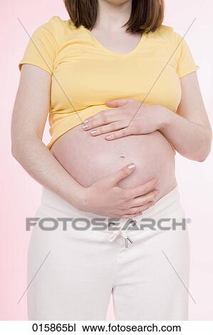detail of pregnant young woman holding her belly View Large Photo Image Stock Image - detail of pregnant young woman holding her belly. Fotosearch