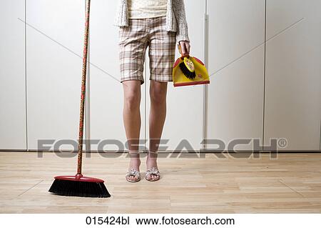 detail of young woman holding broom and dustpan View Large Photo Image Stock Image - detail of young woman holding broom and dustpan. Fotosearch