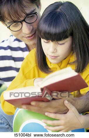 Stock Image - Father and girl reading a book. Fotosearch