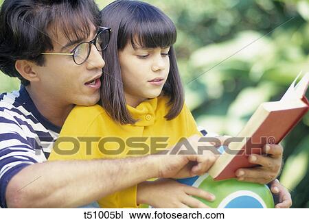 Stock Image - Father and girl reading a book. Fotosearch