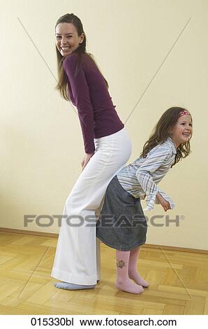 full body portrait of mother and young daughter standing back to back having fun View Large Photo Image Stock Image - full body portrait of mother and young daughter standing back to back having fun. Fotosearch