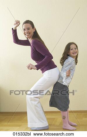 full body portrait of mother and young daughter standing back to back having fun View Large Photo Image Stock Image - full body portrait of mother and young daughter standing back to back having fun. Fotosearch