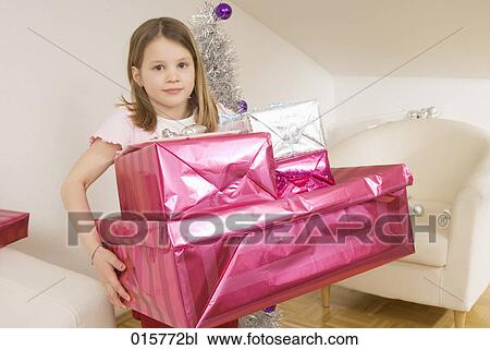 Stock Image - girl carrying christmas presents. Fotosearch