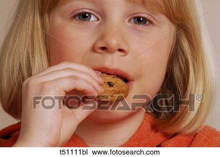 Stock Image - Girl eating a biscuit. Fotosearch