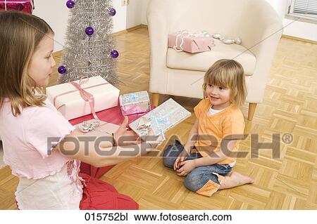 girl giving christmas present to younger sister View Large Photo Image Stock Image - girl giving christmas present to younger sister. Fotosearch