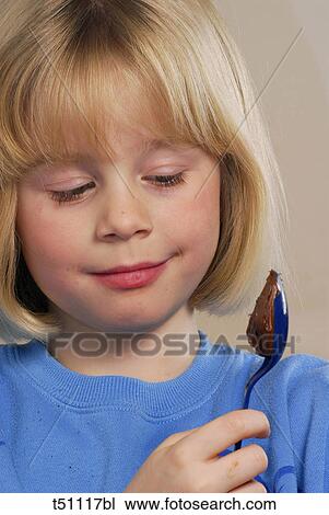 Stock Image - Girl holding a spoon with chocolate. Fotosearch