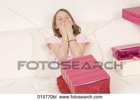 girl sitting on sofa overwhelmed by presents View Large Photo Image Stock Image - girl sitting on sofa overwhelmed by presents. Fotosearch