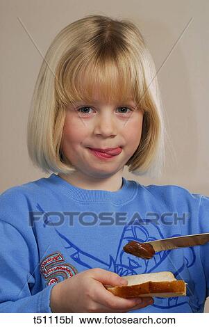 Girl spreading chocolate on bread View Large Photo Image Stock Image - Girl spreading chocolate on bread. Fotosearch
