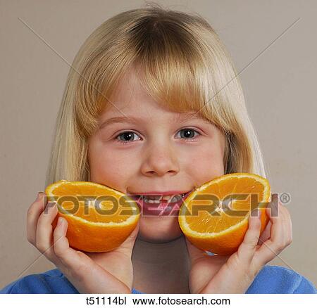 Stock Image - Girl with an orange cut in half. Fotosearch