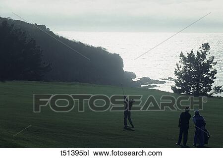 Golfer in action with water view beyond View Large Photo Image Stock Image - Golfer in action with water view beyond. Fotosearch