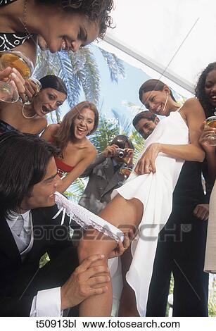Groom removing bride's garter View Large Photo Image Stock Image - Groom removing bride's garter. Fotosearch