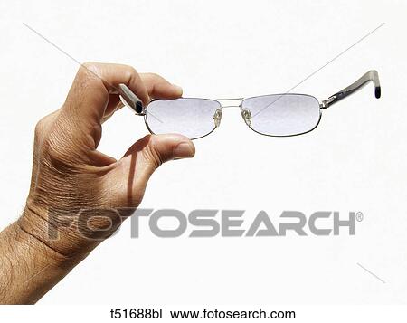 Stock Image - Hand holding eyeglasses. Fotosearch