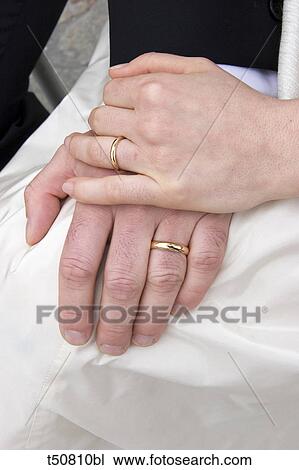 Stock Image - Hands of bride and groom. Fotosearch