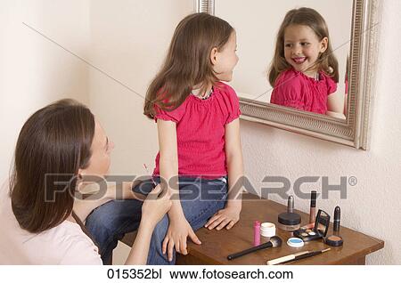 happy young girl wearing lipstick looking at herself in mirror View Large Photo Image Stock Image - happy young girl wearing lipstick looking at herself in mirror. Fotosearch