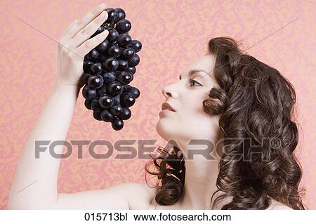 headshot of young woman holding black grapes View Large Photo Image Stock Image - headshot of young woman holding black grapes. Fotosearch