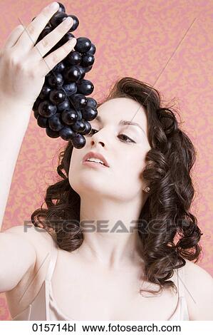 headshot of young woman holding black grapes View Large Photo Image Stock Image - headshot of young woman holding black grapes. Fotosearch