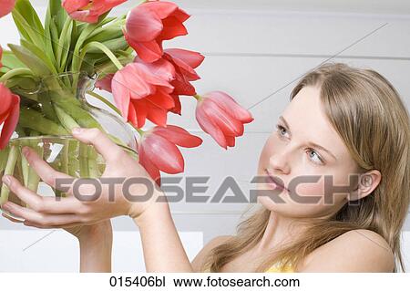 headshot of young woman holding glassbowl with red tulips View Large Photo Image Stock Image - headshot of young woman holding glassbowl with red tulips. Fotosearch