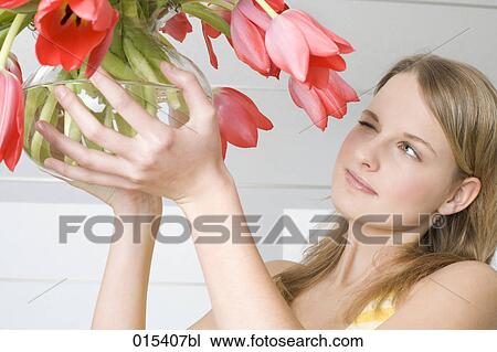 headshot of young woman holding glassbowl with red tulips View Large Photo Image Stock Image - headshot of young woman holding glassbowl with red tulips. Fotosearch