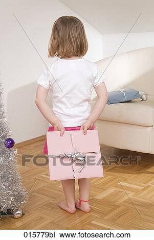 little girl hiding christmas present behind her back View Large Photo Image Stock Image - little girl hiding christmas present behind her back. Fotosearch