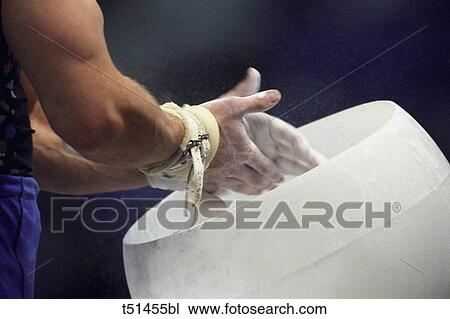 Male gymnast chalking his hands in preparation for his competition View Large Photo Image Stock Image - Male gymnast chalking his hands in preparation for his competition. Fotosearch