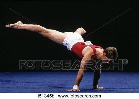 Stock Image - Male gymnast peforming a routine in the floor exercise. Fotosearch