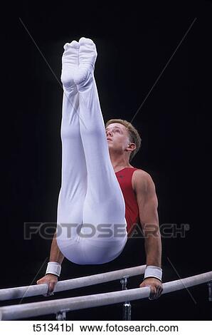 Stock Image - Male gymnast performing on the parallel bars. Fotosearch