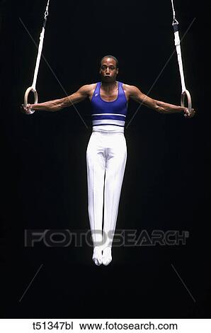 Male gymnast performing on the rings View Large Photo Image Stock Image - Male gymnast performing on the rings. Fotosearch