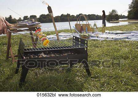 male hand holding barbecue tongs taking shashlik from charcoal grill View Large Photo Image Stock Image - male hand holding barbecue tongs taking shashlik from charcoal grill. Fotosearch