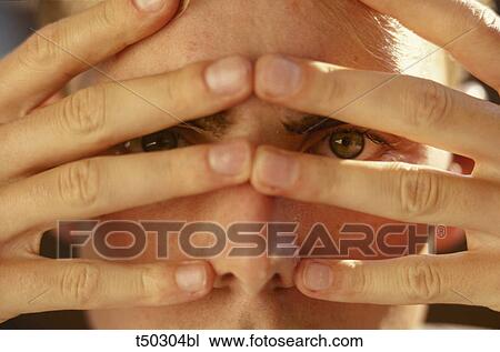 Man hiding face behind fingers View Large Photo Image Stock Image - Man hiding face behind fingers. Fotosearch