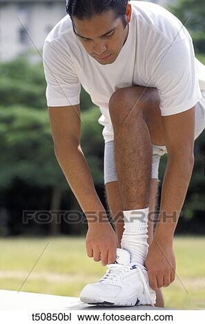 Man lacing up shoes View Large Photo Image Stock Image - Man lacing up shoes. Fotosearch