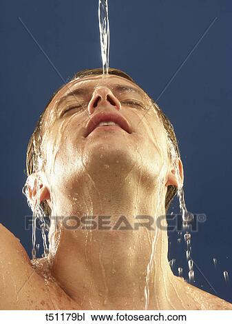 Stock Image - Man poruing water on his face. Fotosearch