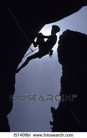 Man rock climbing in shadow View Large Photo Image Stock Image - Man rock climbing in shadow. Fotosearch