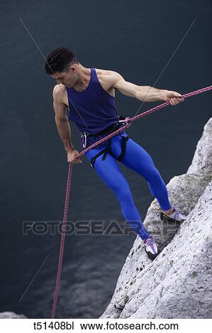 Man rock climbing looking down View Large Photo Image Stock Image - Man rock climbing looking down. Fotosearch