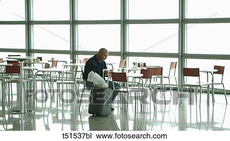 Man sitting at cafe of airport View Large Photo Image Stock Image - Man sitting at cafe of airport. Fotosearch